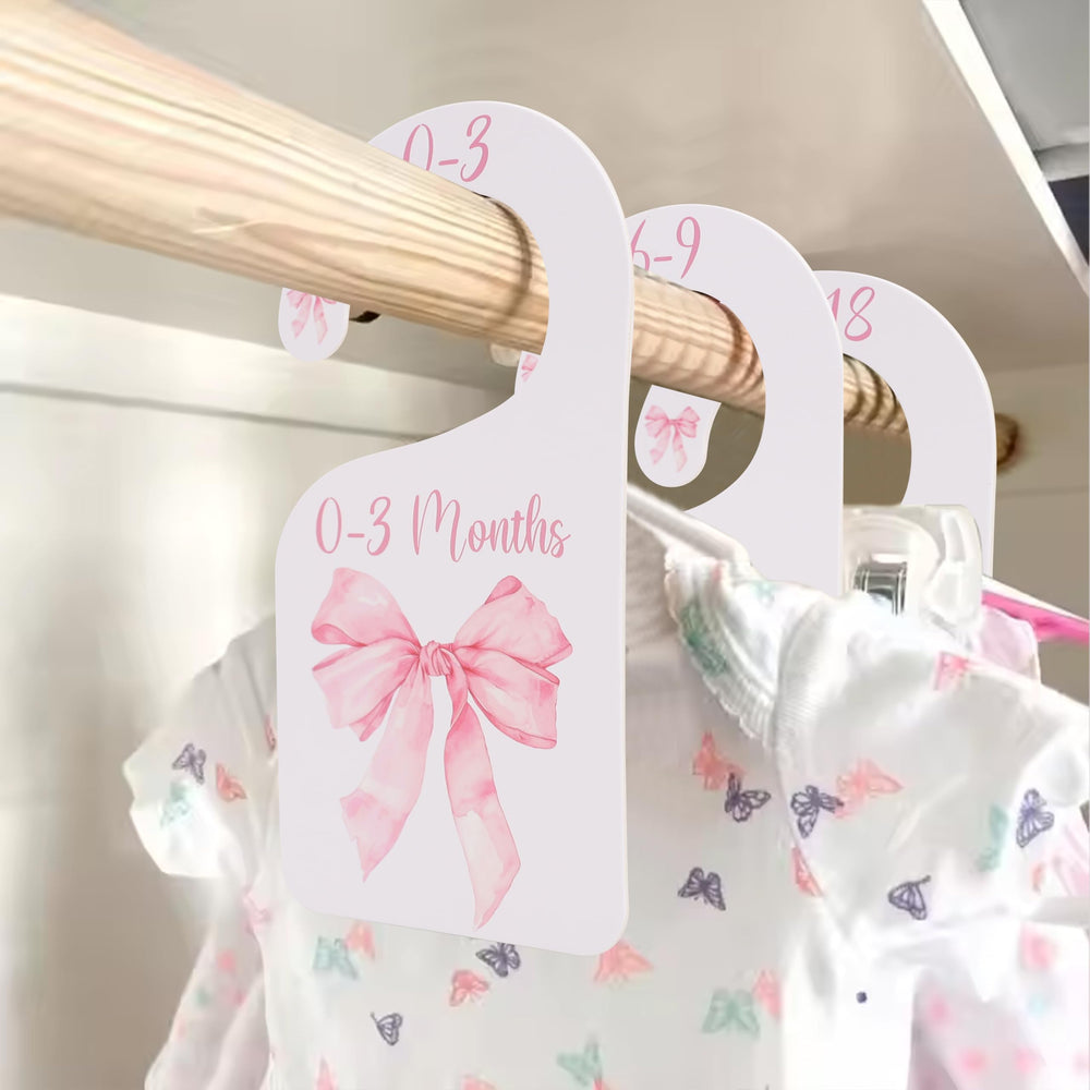 UOAOU bow-nursery-closet-divider-pink keeps newborn outfits neatly organized.