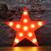 Vicila LED Marquee Star Sign red on wall emits warm cozy glow.