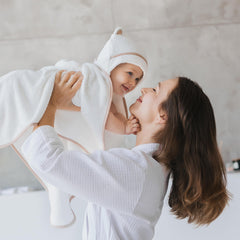 Warm Cuddles newborn hooded towel on infant illustrates cozy warmth.