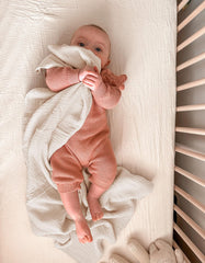 Wimist muslin swaddle blanket wrapped around baby for secure, cozy swaddling