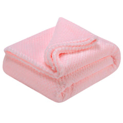 Wonder Miracle fuzzy throw blanket in baby pink folded beside cushions for versatile home comfort.