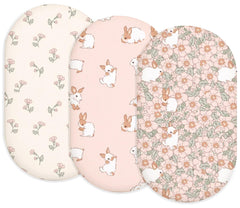 Woodiville Bassinet Sheets Blush Bunny two-pack on clean bed for newborn comfort