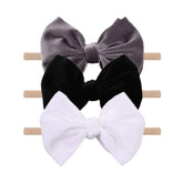 YanJie velvet bow on a black headband showing soft texture and gentle padding for newborns