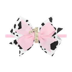 YanJie cow-print bow on newborn headband for first birthday photo-ready style.