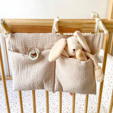 YeeMan cotton baby bedside bag in oatmeal hangs on crib for convenient storage.