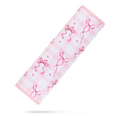 YR seat belt cover in pink bows cushions kids during car rides.