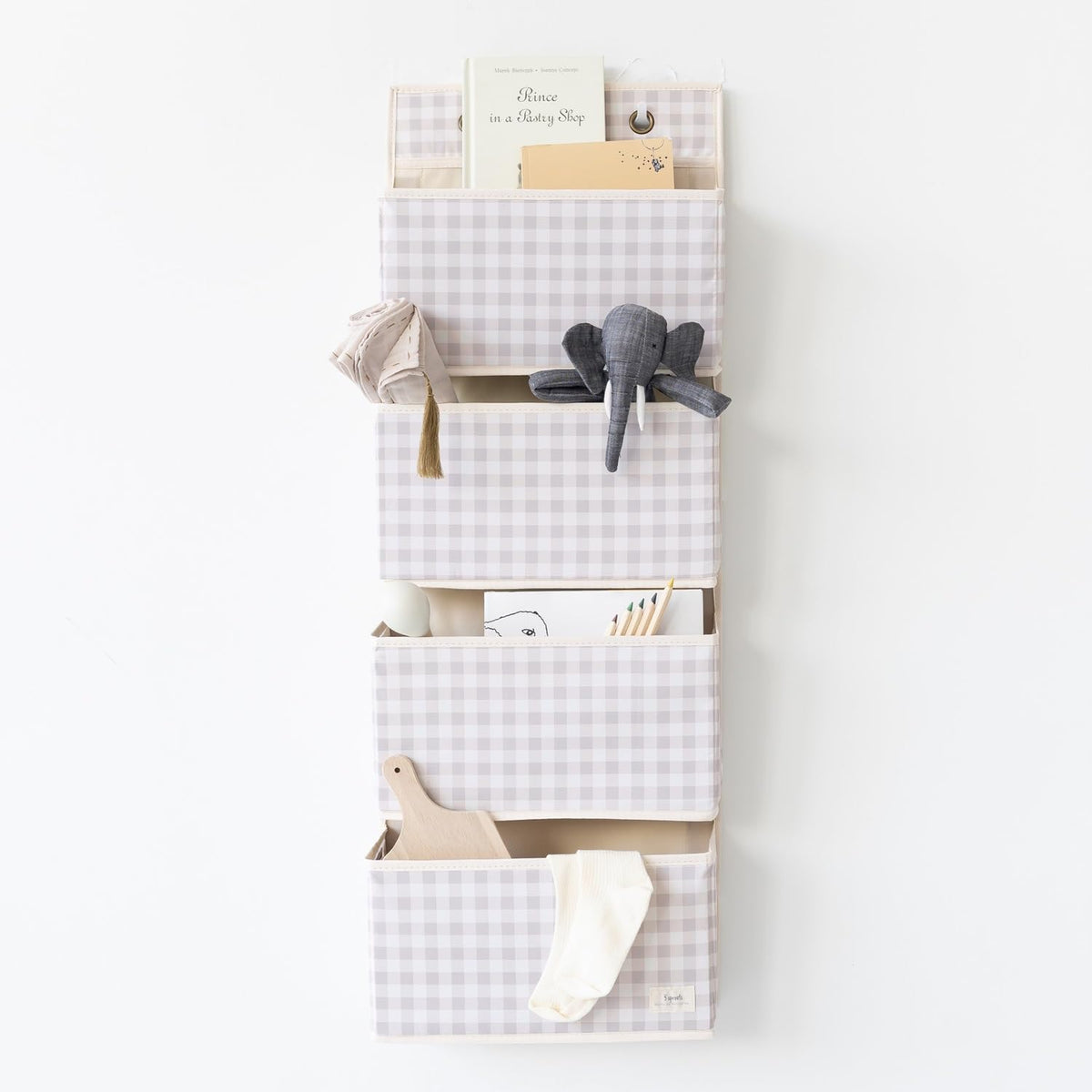 3 Sprouts over-the-door organizer in gingham beige with four pockets for diapers and toys.