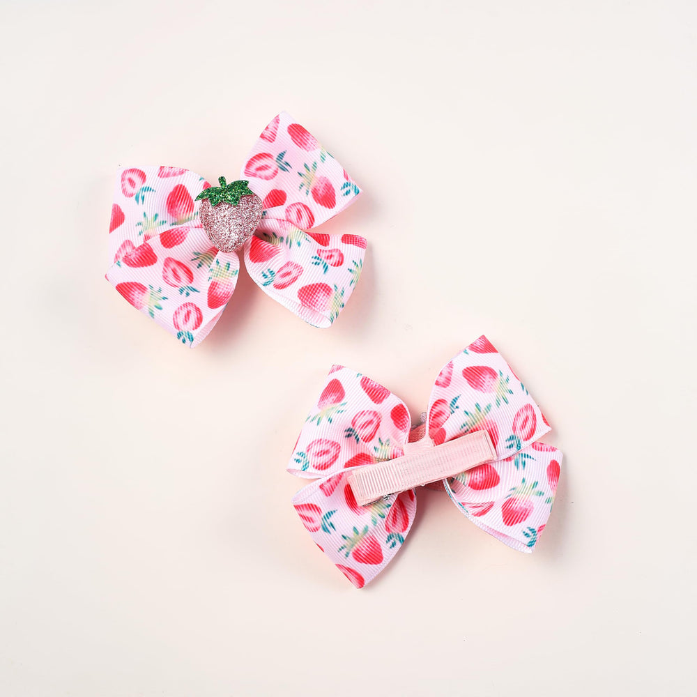 AACKS strawberry bows clipped into braids for a cheerful look.