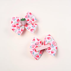 AACKS strawberry bows clipped into braids for a cheerful look.