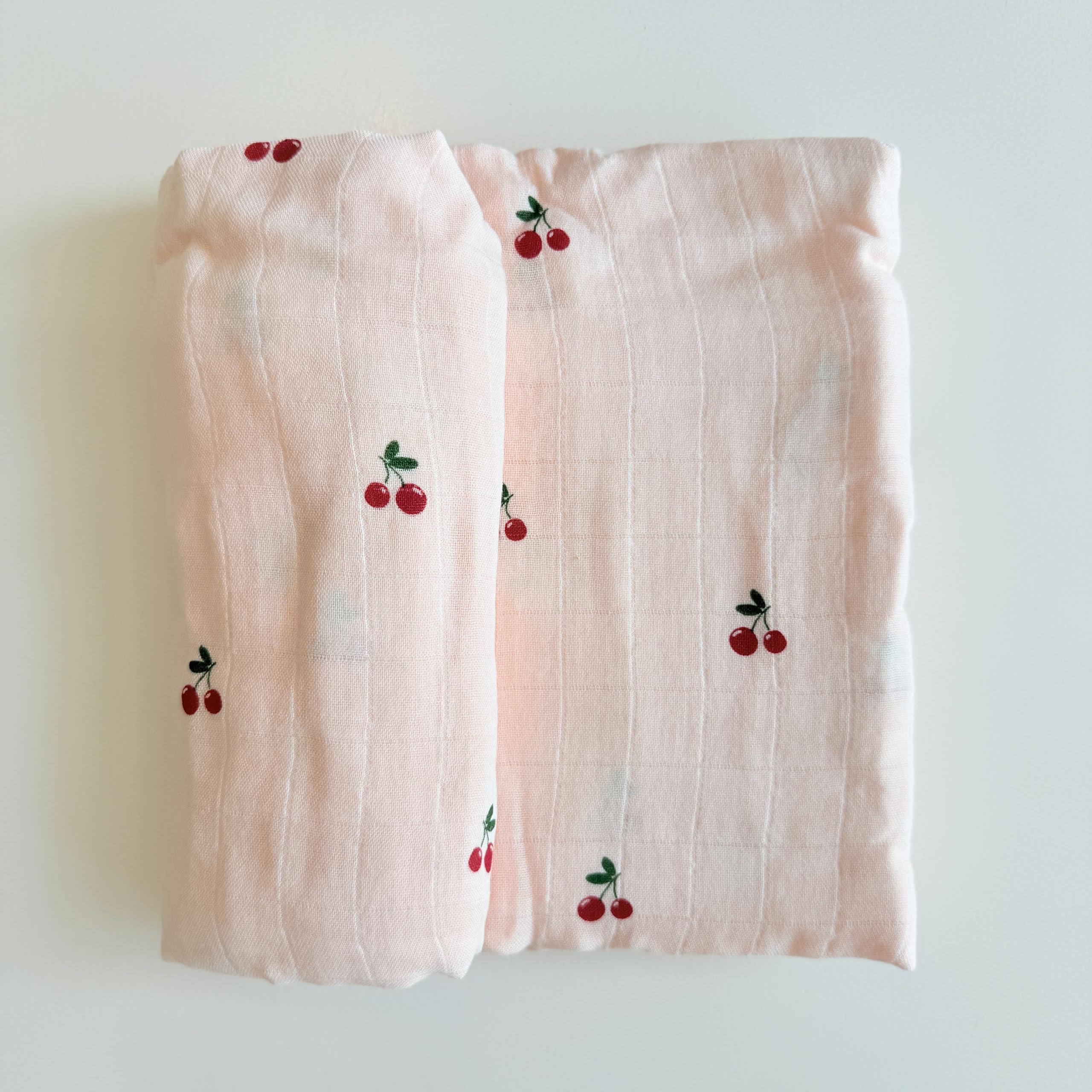 Ali+Oli baby cherry swaddle shown as car seat cover and nursing wrap.