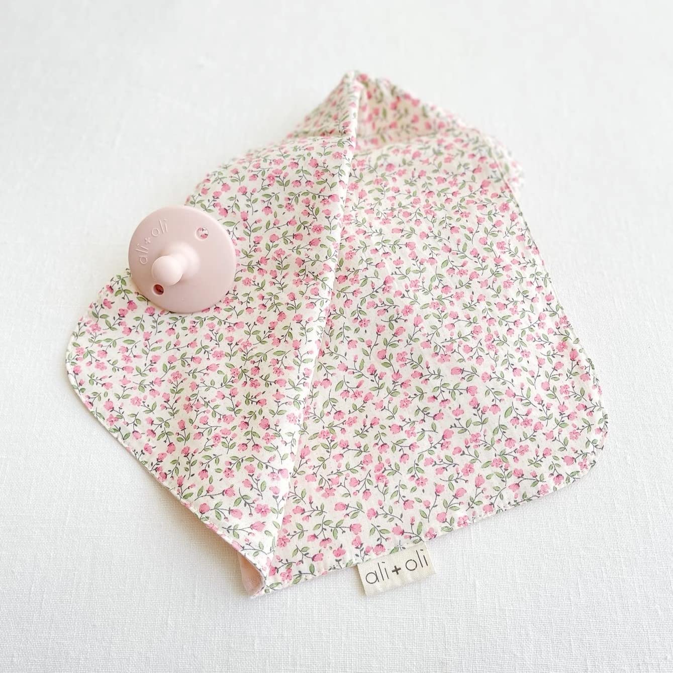 Ali+Oli cuddle blanket in pink flowers adds gentle texture and comforting look.