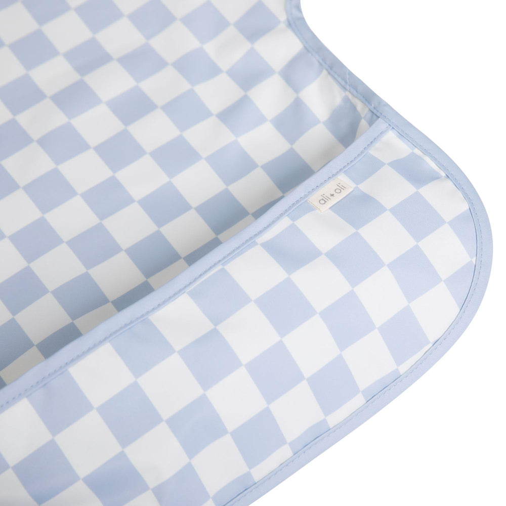 Ali+Oli blue checkers smock bib back view showing sleeve coverage.