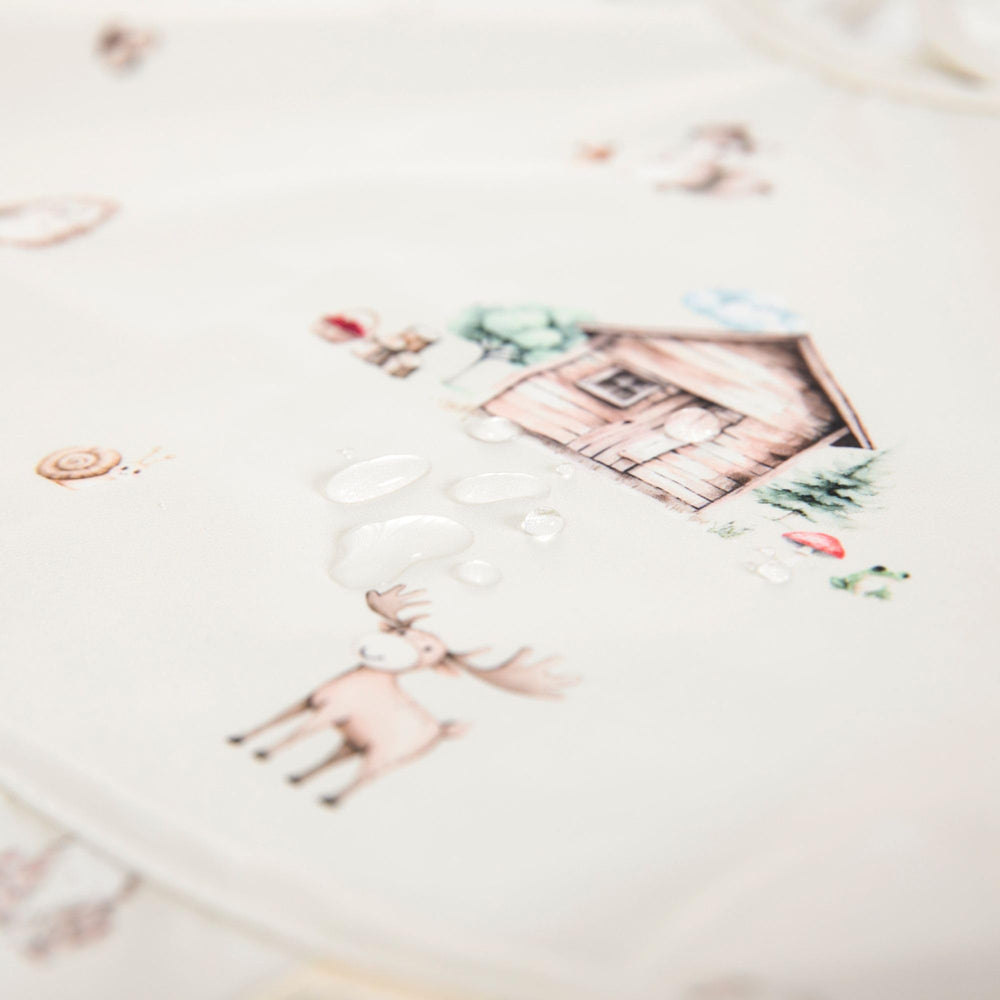 Ali+Oli Smock Bib catches spills, reducing cleanup time during mealtime.