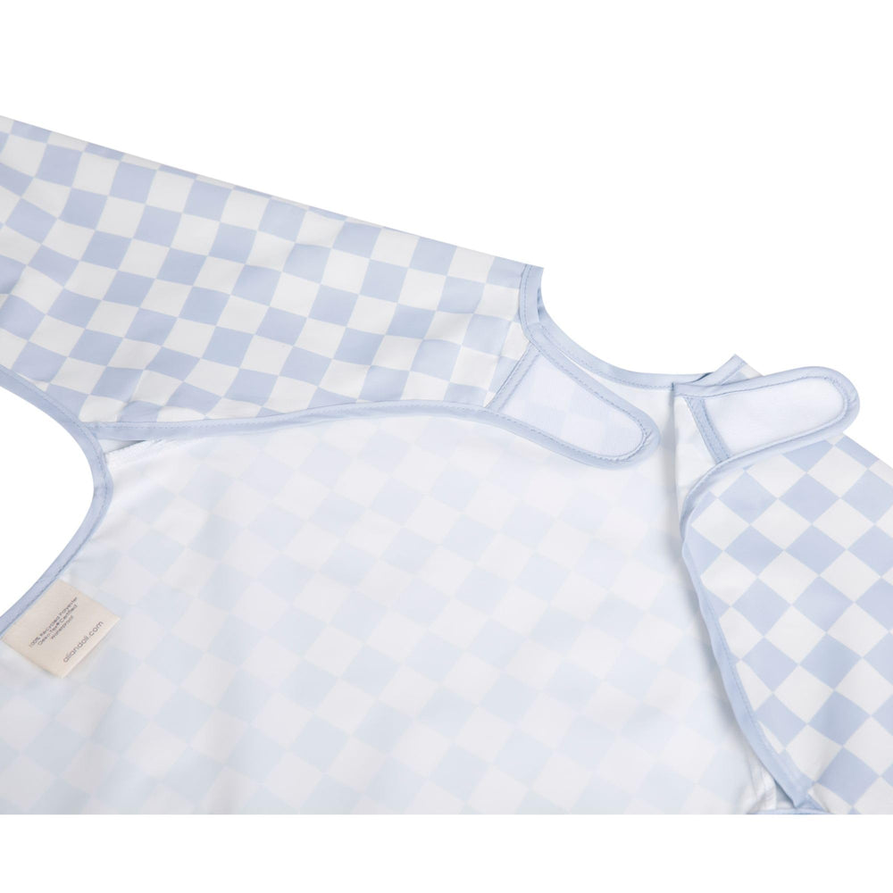 Ali+Oli blue checkers smock bib long-sleeve fit on toddler.