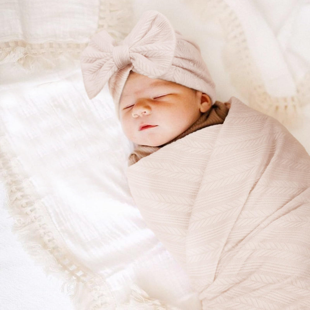 AQOKKA baby swaddle used as a photo prop in a nursery setting.