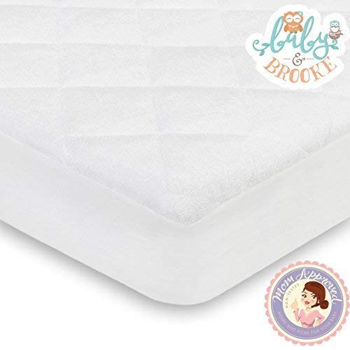 Baby and Brooke absorbent core in crib protector soaking up spills.