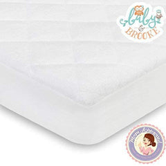 Baby and Brooke absorbent core in crib protector soaking up spills.