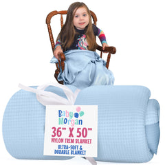 Baby Morgan blue waffle blanket shown in a cozy crib setup for soft naps.