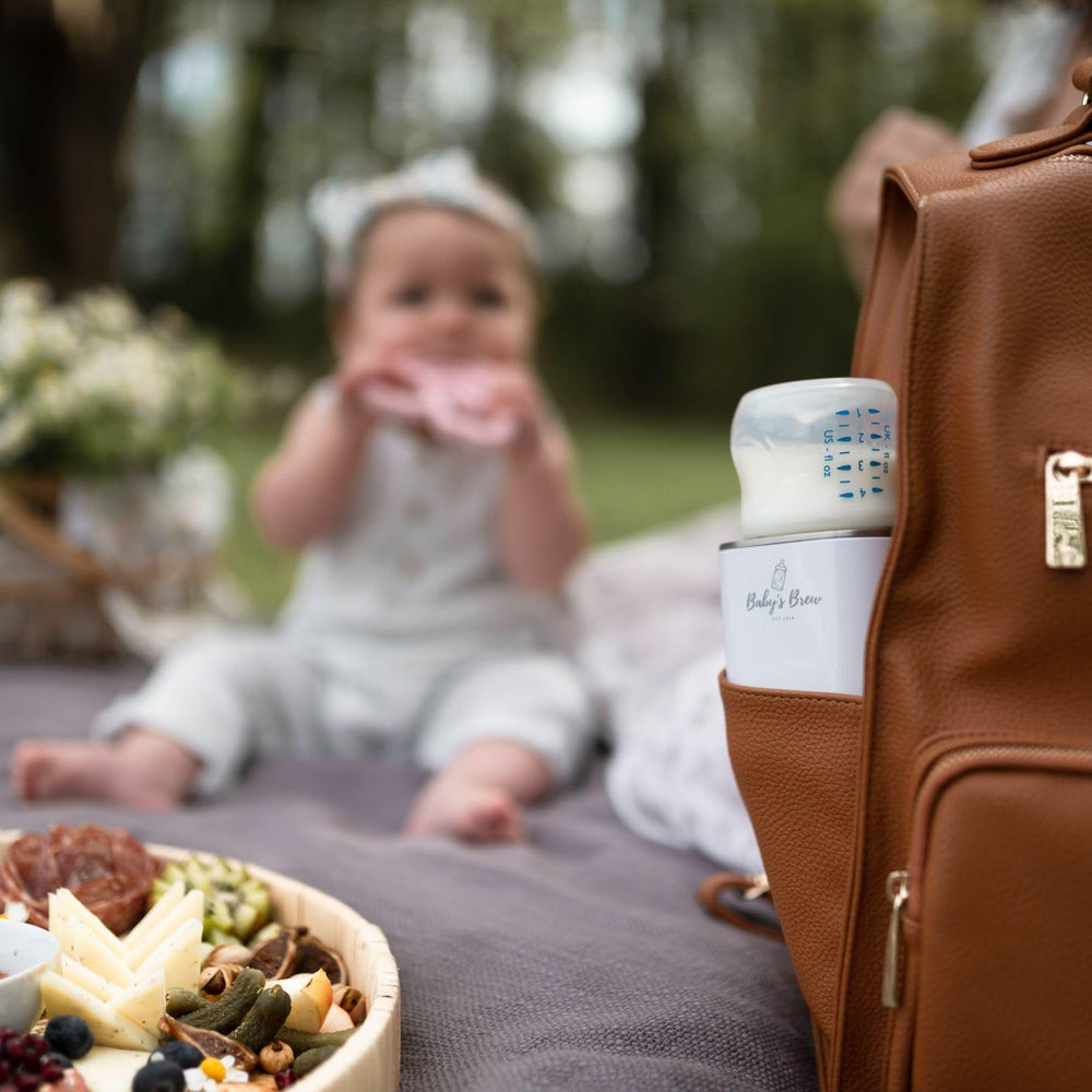 Baby’s Brew warmer in a diaper bag emphasizes portable on-the-go use.