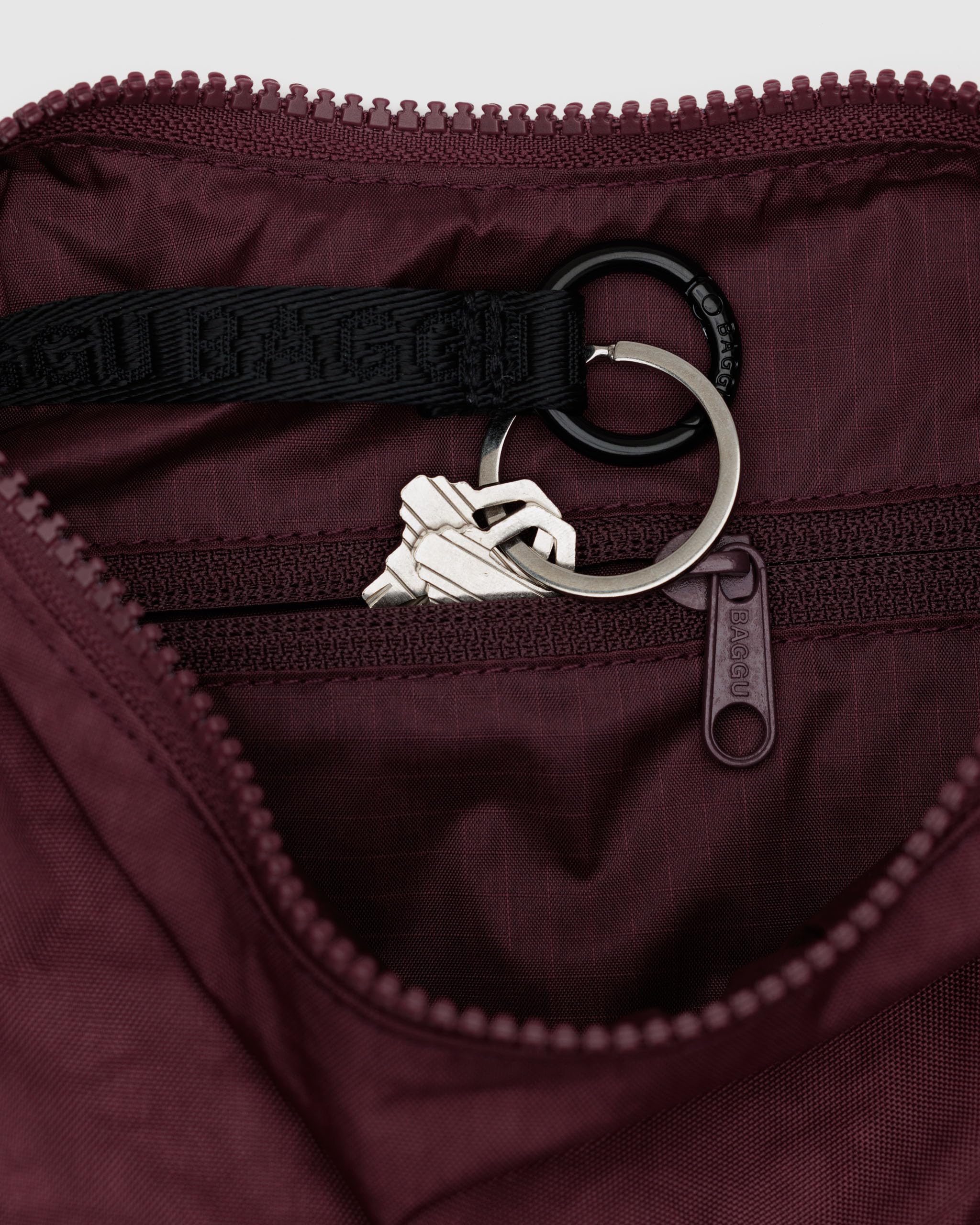 BAGGU crescent bag in mahogany, side view, keeps cards and keys organized with a secure strap.
