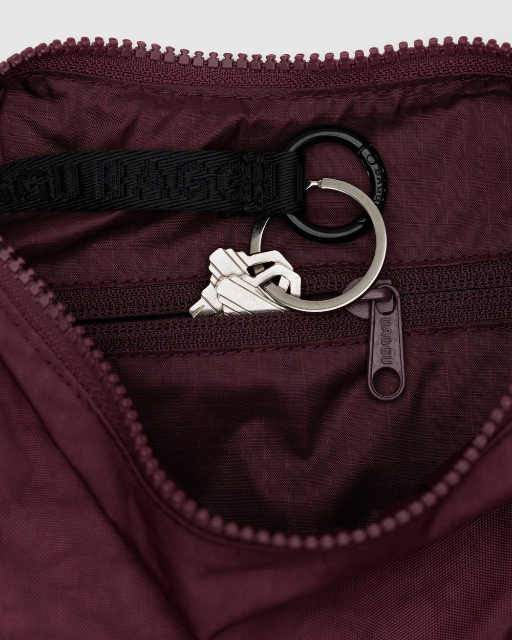 BAGGU crescent bag in mahogany, side view, keeps cards and keys organized with a secure strap.