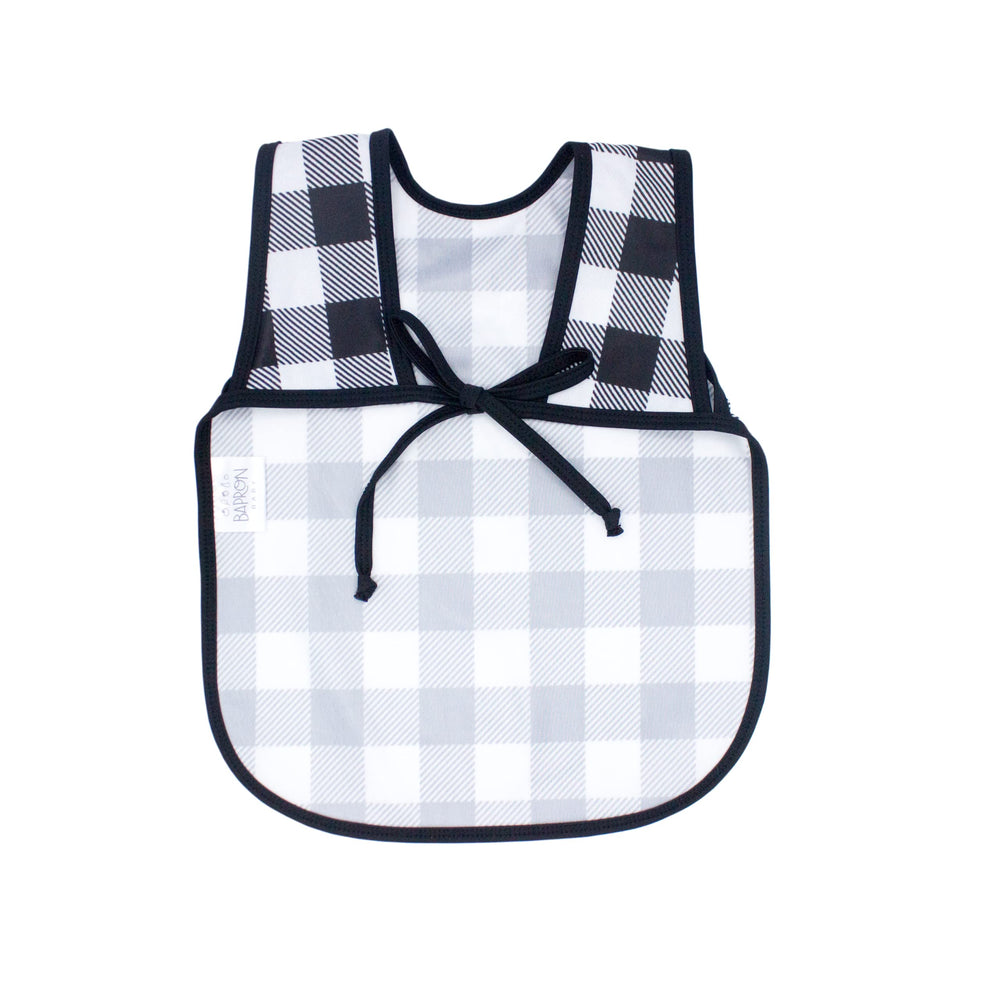 BapronBaby mealtime setup with white buffalo plaid bib protecting clothes from spills.