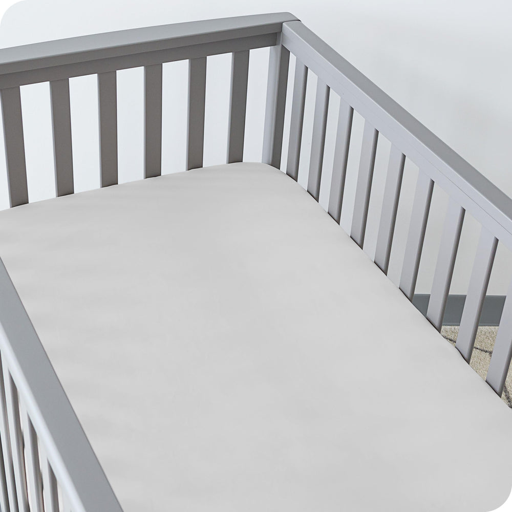 Bare Home elasticized edge on a crib sheet illustrating full wrap fit.