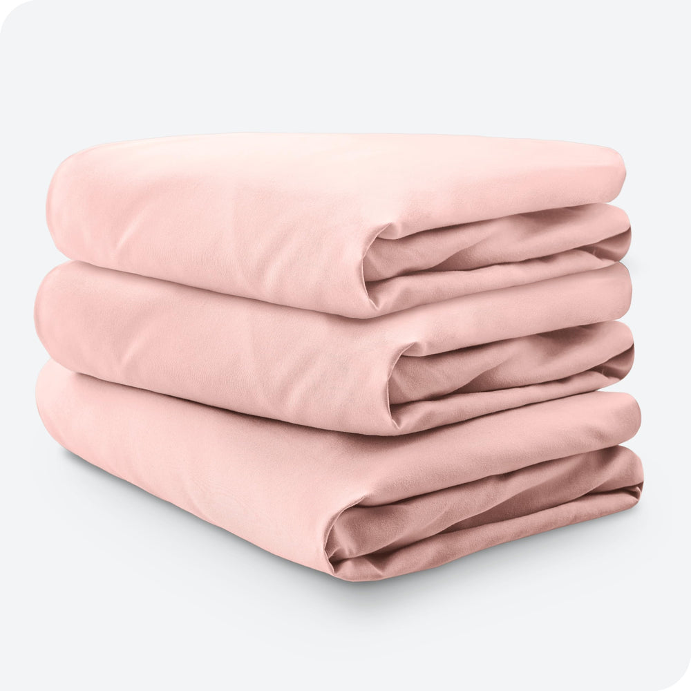 Bare Home pink slipper crib sheet on mattress demonstrates cozy nursery styling.