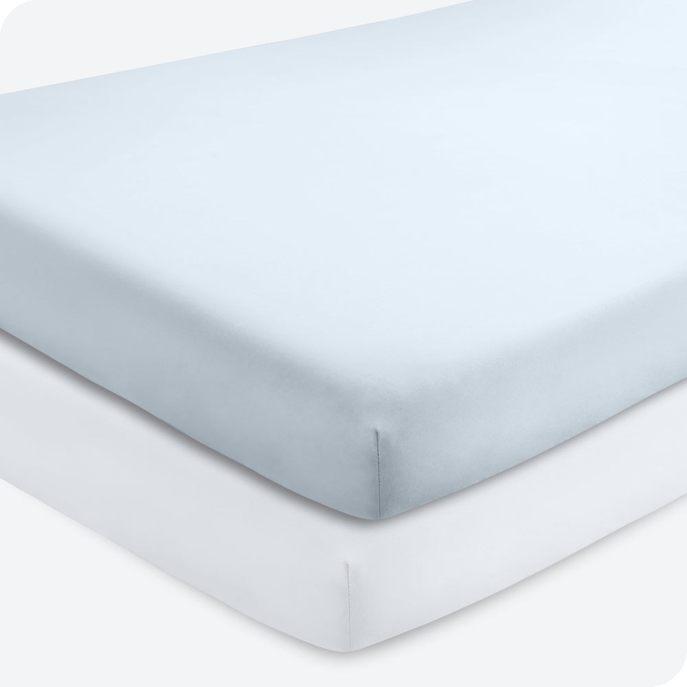 Bare Home sky blue and white crib sheet on a mattress, offering a secure, snug fit.