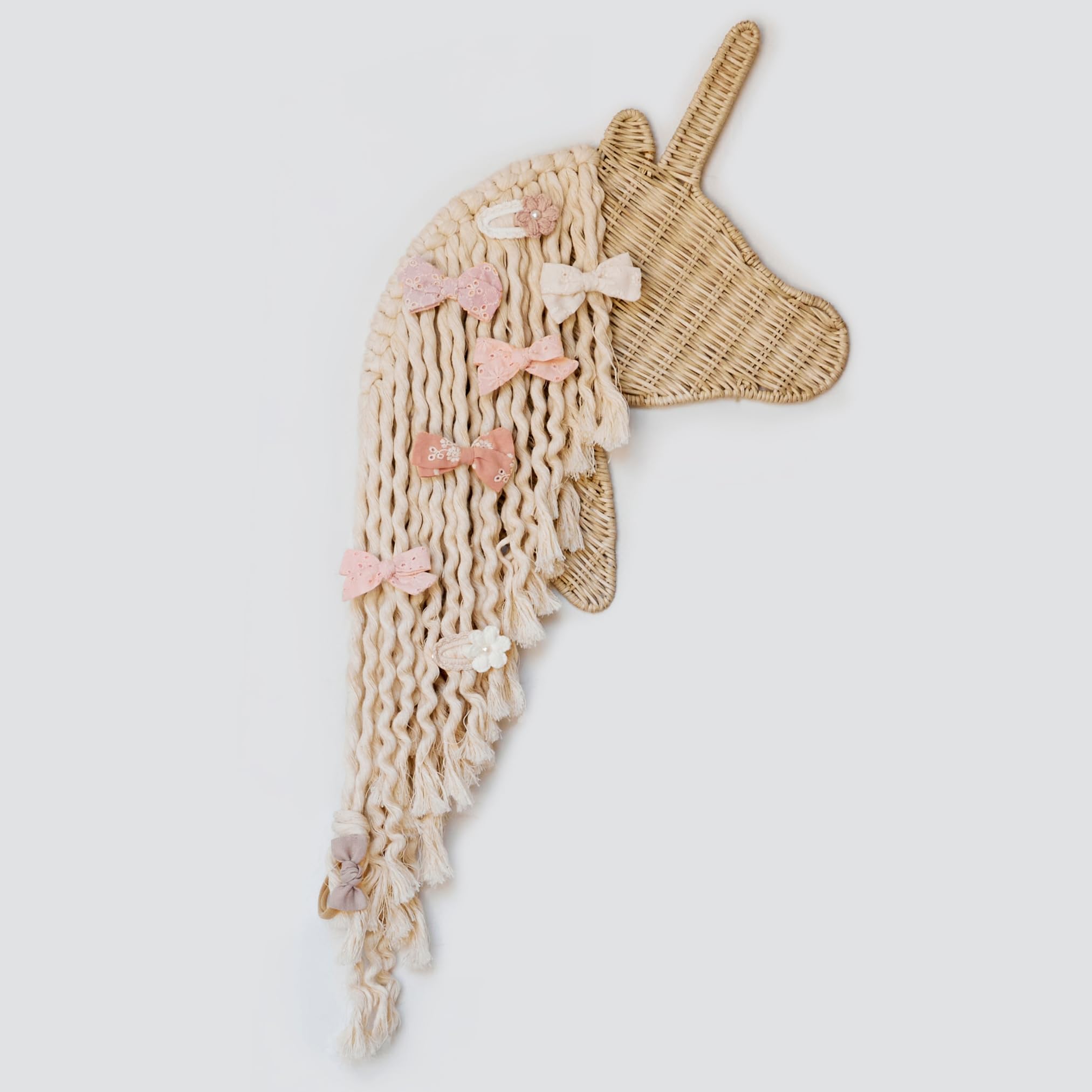 Bebe Bask Bowie the Unicorn bow holder in boho macrame keeps bows organized in a girl's room.
