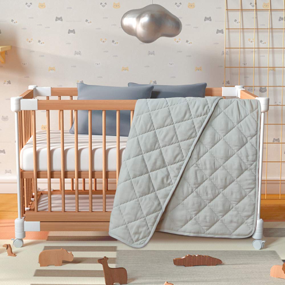 BEDSUM crib quilt on baby bed showing compact size and design.