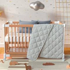 BEDSUM crib quilt on baby bed showing compact size and design.