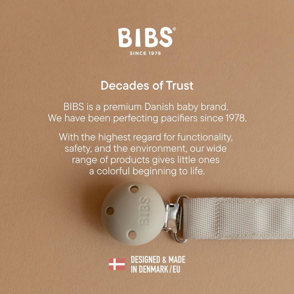 BIBS pacifier clip ribbon blush in use on stroller strap for travel-friendly design