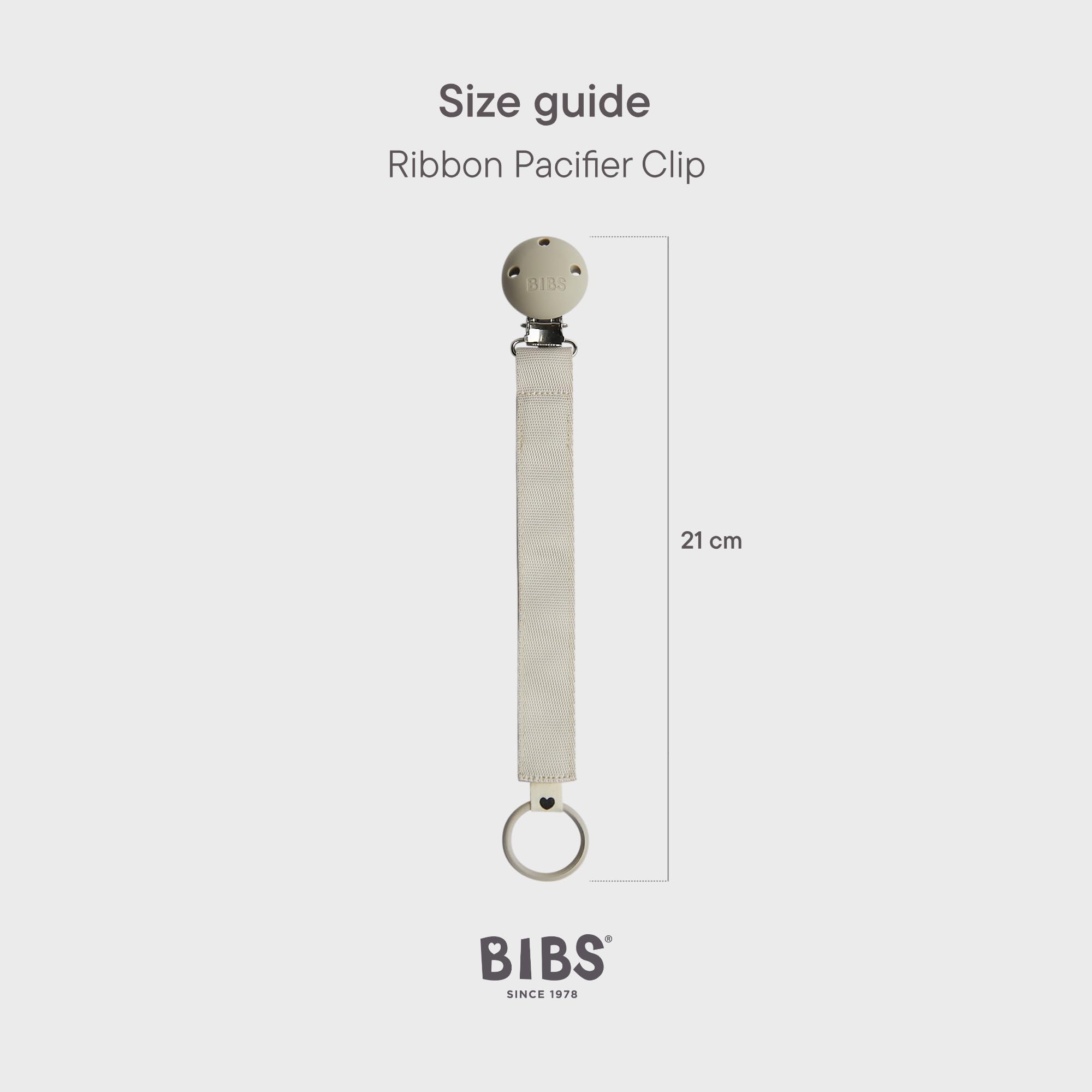 BIBS pacifier clip ribbon blush worn on a baby outfit demonstrates hands-free convenience