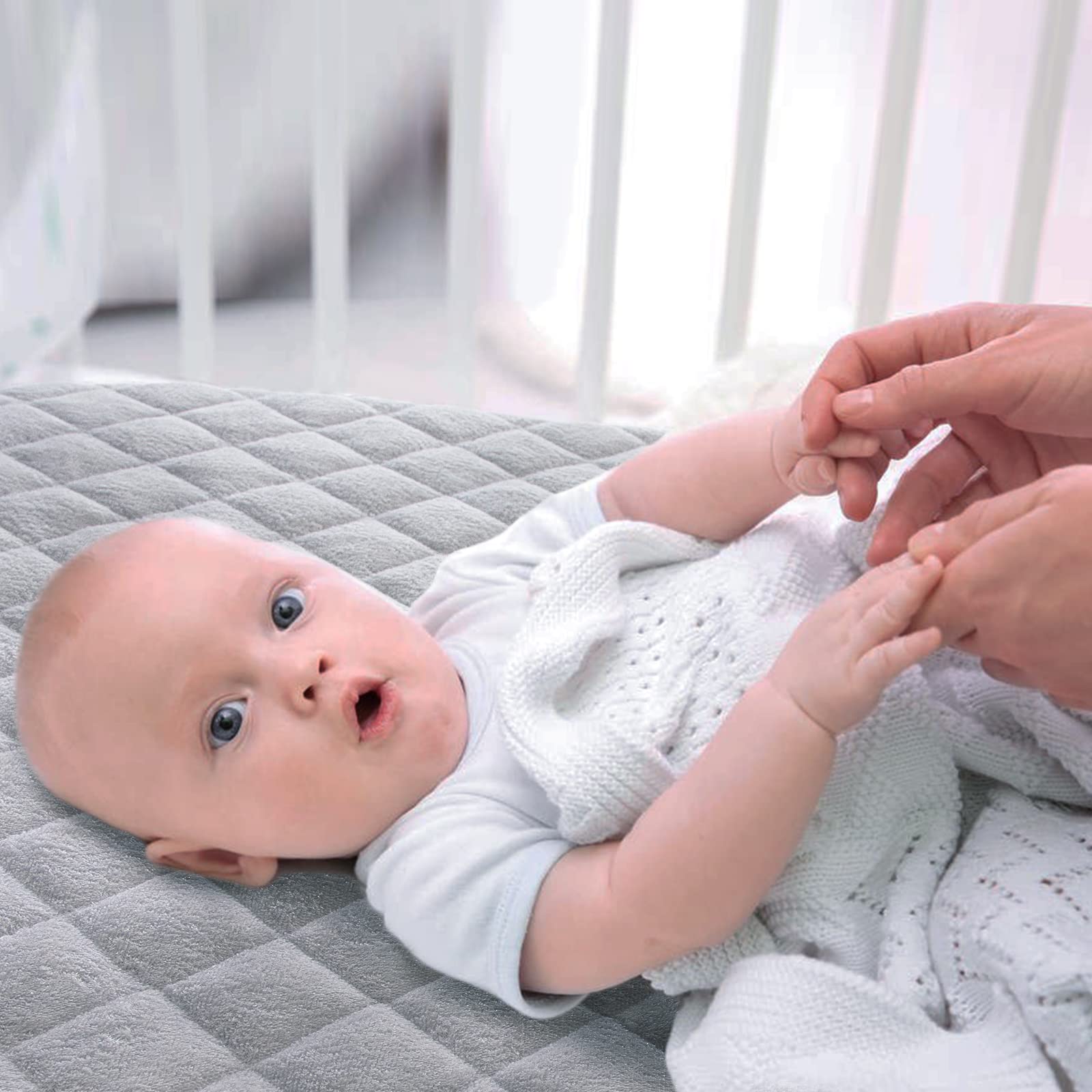 Biloban gray crib protector cover blends with nursery decor.