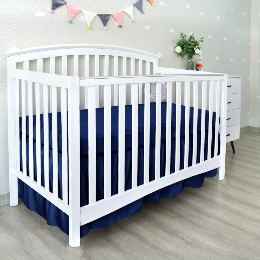 Biloban navy crib skirt complements nursery decor while keeping the space tidy.