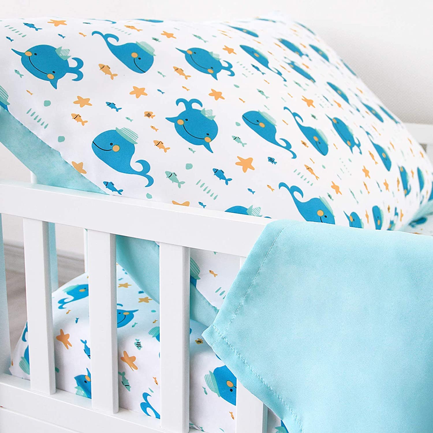 Biloban Whale toddler sheet fitted on bed shows secure elastic edges.