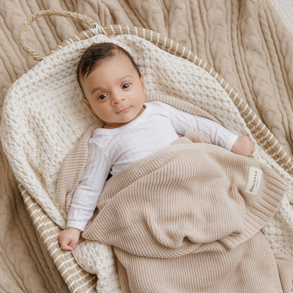 Gift-ready Bleu La La blanket with monogrammed ribbon for welcoming newborns.