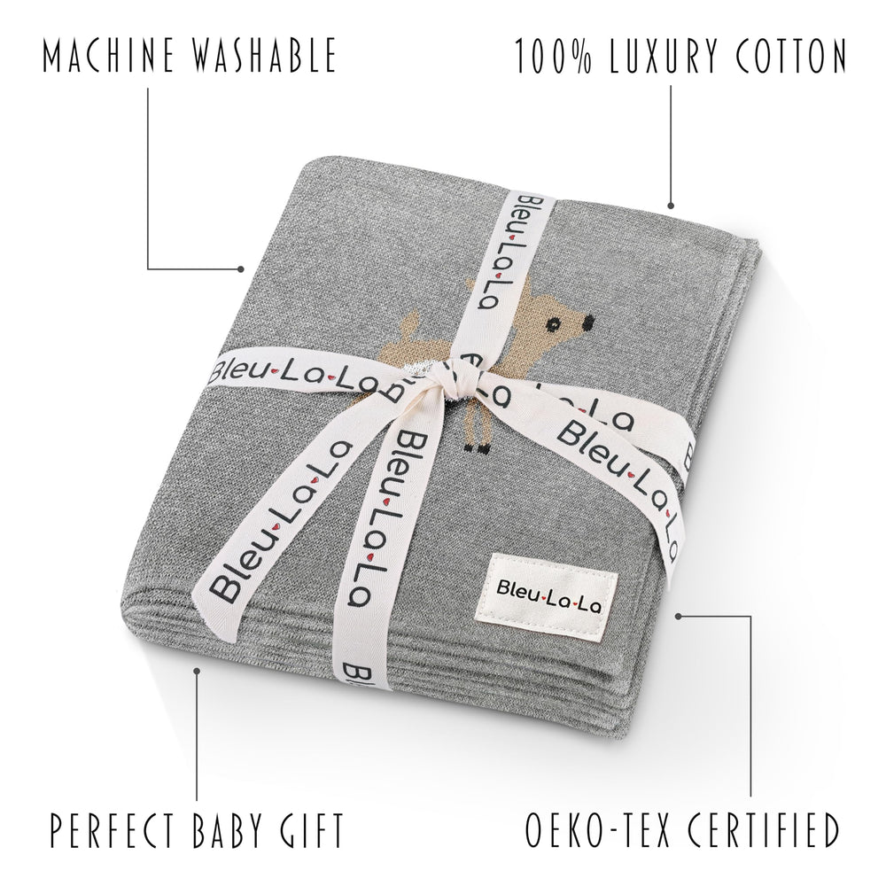 Bleu La La knit swaddle in deer grey draped over crib for calm sleep