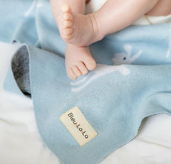Bleu La La nursery decor blanket with llama motif adds warmth.