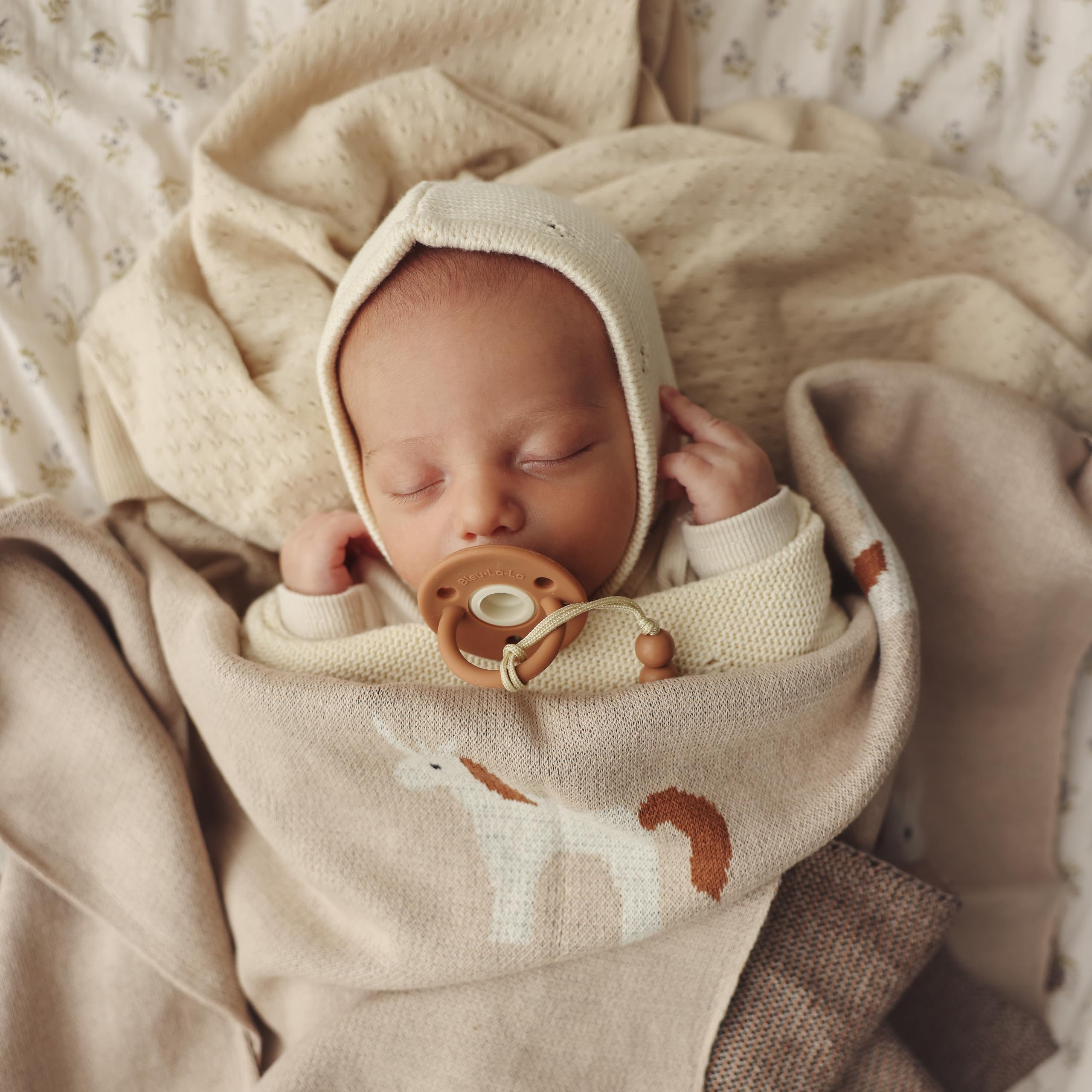 Bleu La La Unicorn Cream blanket swaddle on infant for cozy, secure comfort.