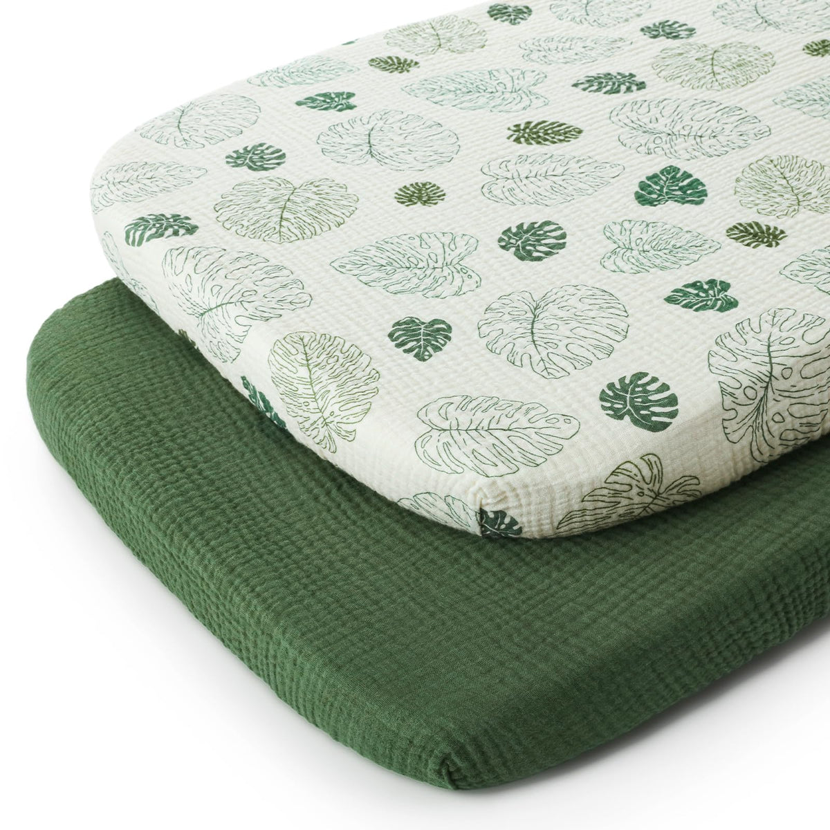 Blissful Diary monstera pattern bassinet sheet offers breathable muslin comfort for oval mattresses.