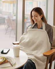 Blissful Diary cream nursing apron with adjustable straps stays secure during on-the-go feeds.