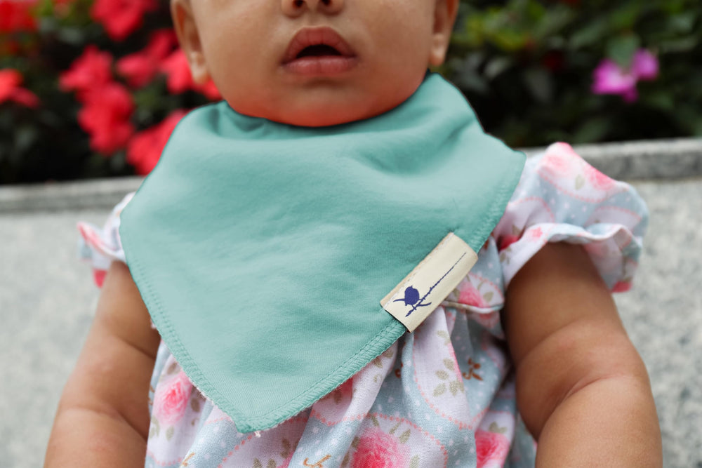 Blue Wren bib worn by baby with gender-neutral pattern during daily wear.