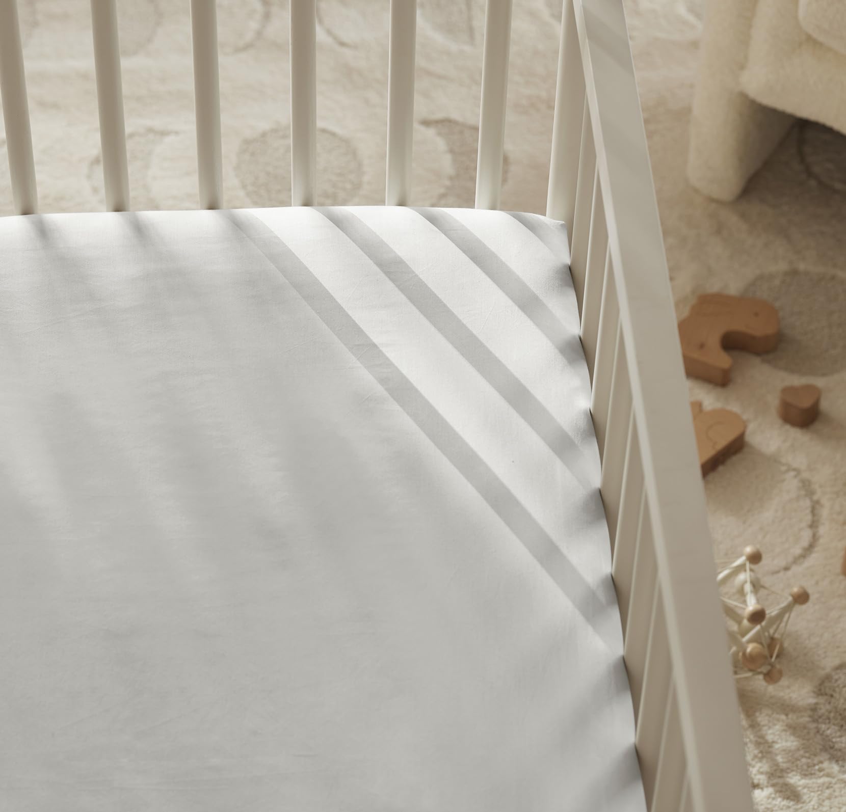 Boll & Branch crib sheet care instruction photo illustrating cold wash and tumble dry