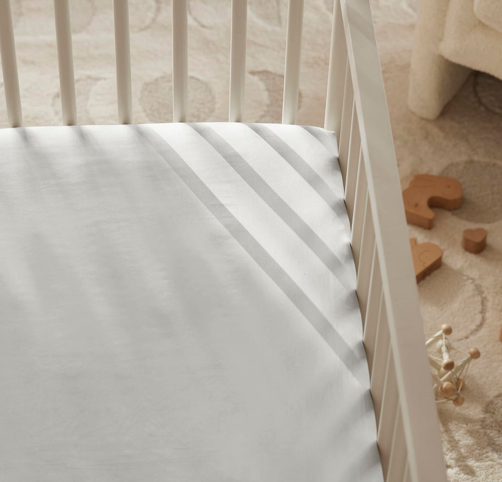 Boll & Branch crib sheet care instruction photo illustrating cold wash and tumble dry