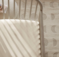 Boll and Branch crib sheet fitted elastic band for snug mattress grip during nightly movements.