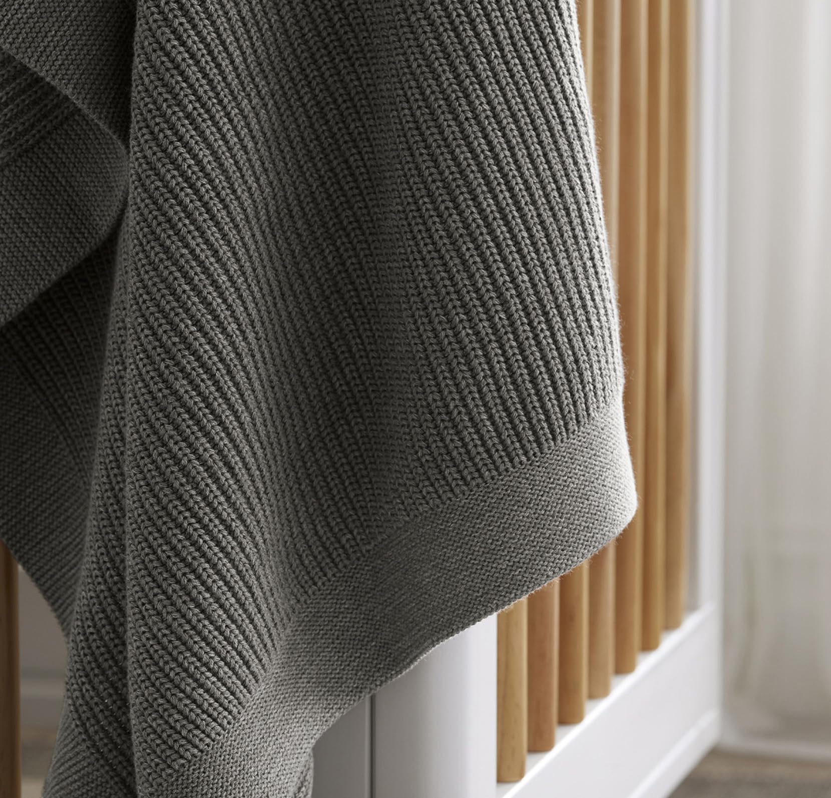 Boll & Branch ribbed knit blanket demonstrates growth-friendly size as baby ages.
