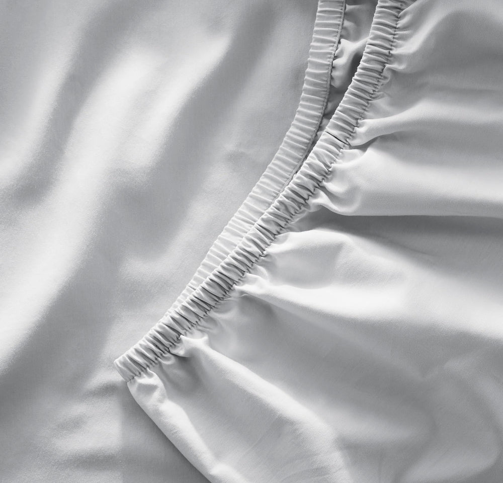 Boll & Branch Sky crib sheet with secure top-stitched elastic band for snug fit