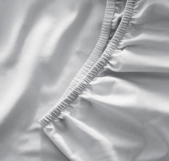 Boll & Branch Sky crib sheet with secure top-stitched elastic band for snug fit